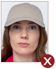 Image of unacceptable passport photo, person has hat on head