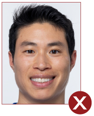 Unacceptable passport photo, person smiling